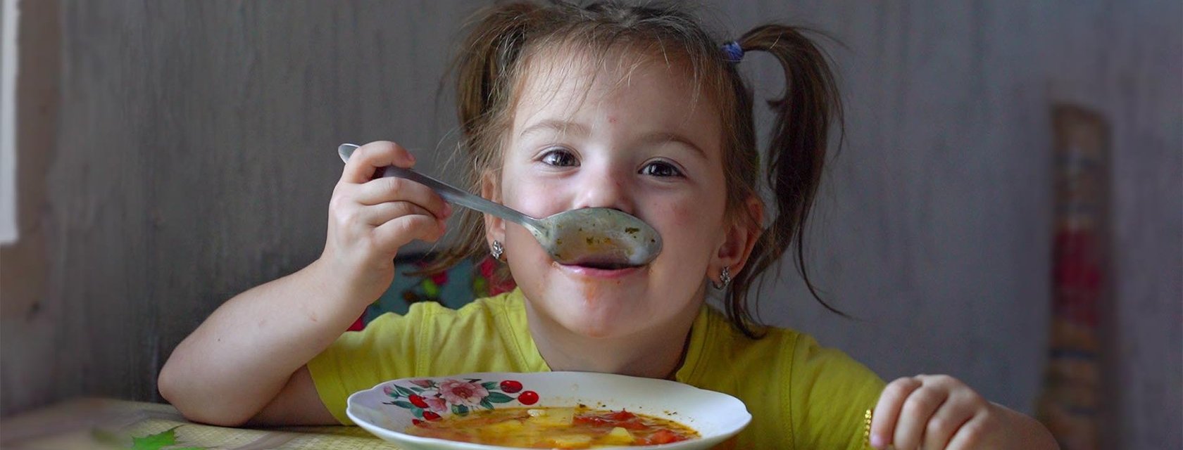 Mädchen in Moldau isst Suppe